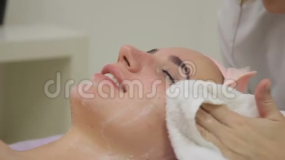美容师在医疗诊所清洗年轻妇女的脸视频的预览图