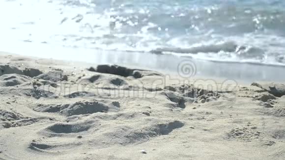女孩坐在海滩上从手心里倒出沙子视频的预览图
