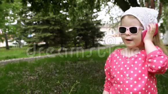 小女孩在公园里用儿童电话说话视频的预览图
