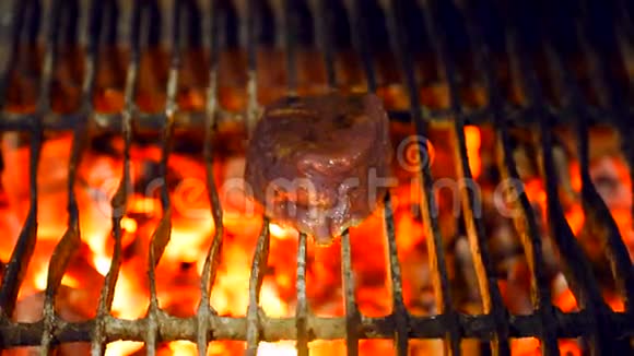 一块新鲜多汁的猪肉在煤上烤在烤架上煮肉视频的预览图