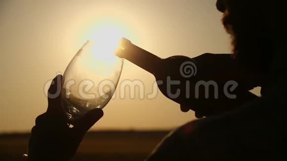 农夫喝一杯白葡萄酒又是日落的天空无法辨认的男性手拿着酒杯在露台上贷款视频的预览图