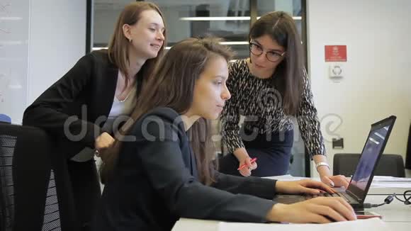 三名妇女在大公司使用笔记本电脑视频的预览图