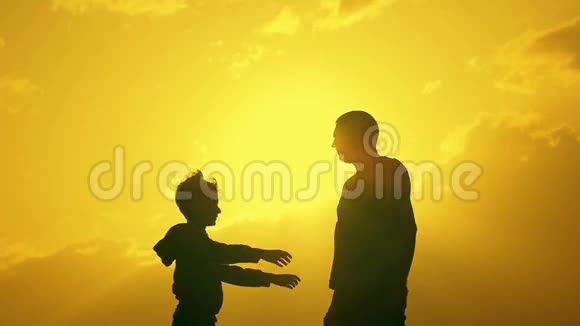 儿子在夕阳背景下拥抱父亲的剪影视频的预览图
