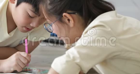 亚洲青少年男孩和他的妹妹一起在家做手工带着微笑的脸视频的预览图