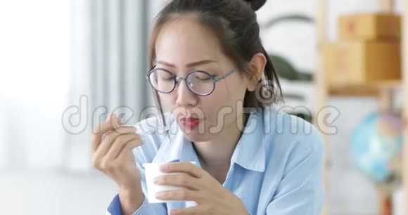 快乐的亚洲女孩喜欢吃冰淇淋和微笑的脸在家里视频的预览图