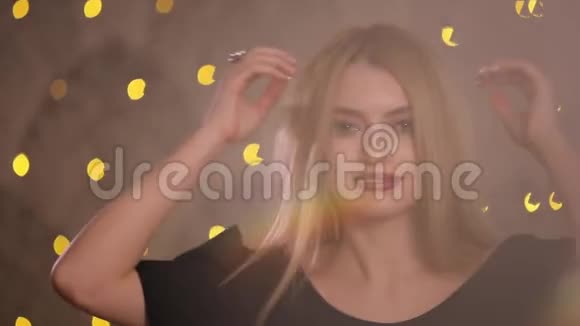 在摄像机上摆姿势调情的女人慢动作黄色背景视频的预览图