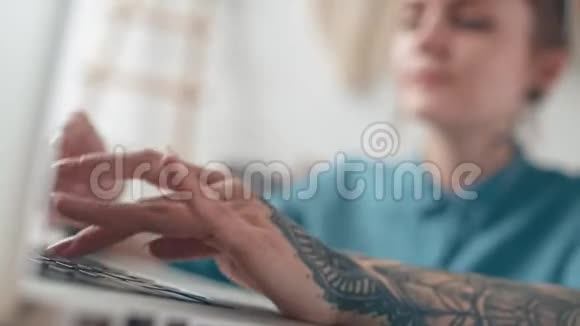 手臂上有一个大纹身的女人打字交流工作视频的预览图