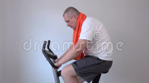 骑着运动自行车带毛巾的快乐男人视频的预览图