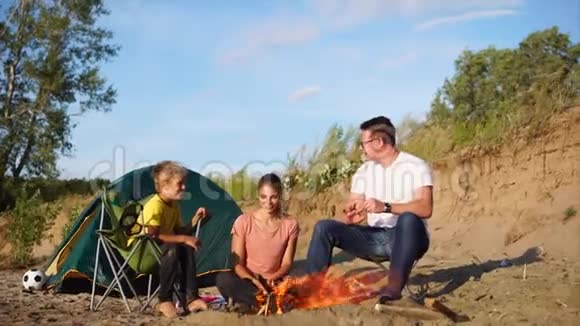 一家人周末在露天的篝火附近的露营区度过视频的预览图