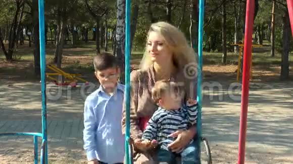 妈妈和孩子们在秋千上视频的预览图