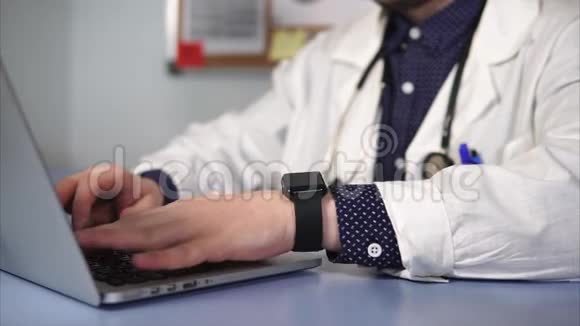一位成人医生的手特写镜头他在笔记本电脑键盘上打印文本视频的预览图