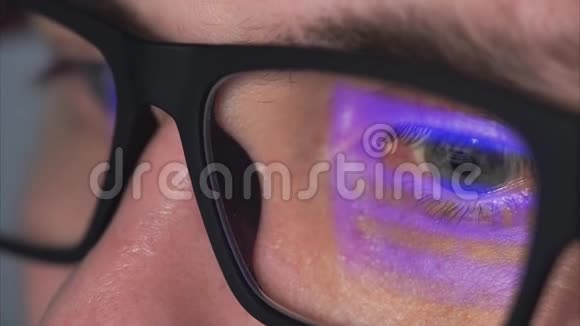一个戴着眼镜人的眼睛近距离观察电脑显示器视频的预览图