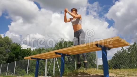 年轻健康活跃的女人板凳跳蹲跳城街健身女孩在户外锻炼视频的预览图
