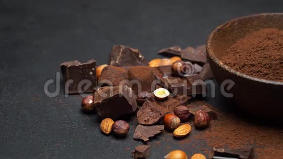 黑巧克力块坚果和可可粉放在深色混凝土背景的木碗里视频的预览图