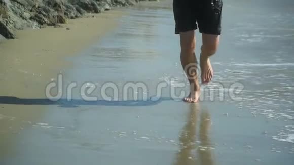 人类赤脚在海边的海滩上奔跑慢动作视频的预览图
