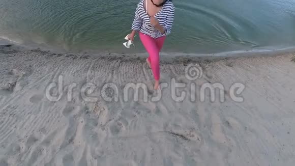 美丽的女孩给相机送上一个空中吻从海滩上的水中出来视频的预览图