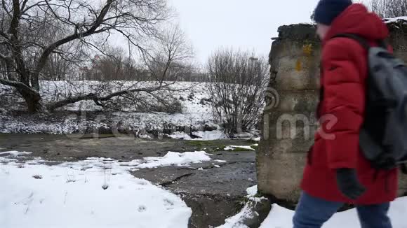 旅行者一个带背包的男性跟踪者去了小溪附近的一个废弃的地方乌云密布视频的预览图