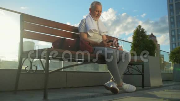 快乐运动的老人坐在长凳上视频的预览图