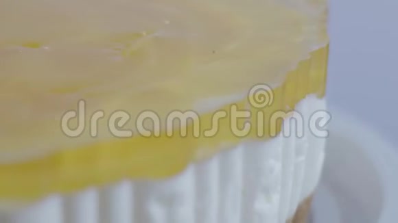 在一个白色的盘子上特写一个美味的水果蛋糕桃派一朵玫瑰形状的水果片旋转着视频的预览图