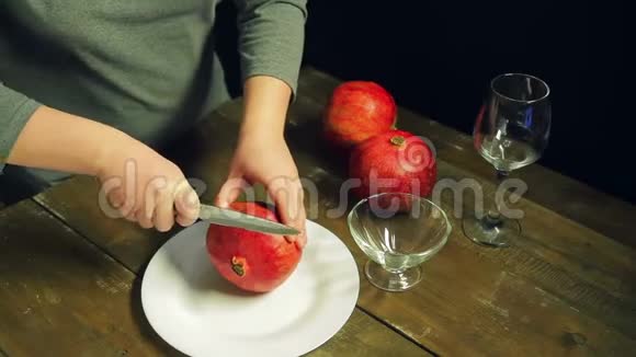 女人刀刀石榴果放在木桌上的白板上视频的预览图