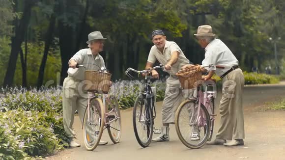 公园里有三个骑自行车的老朋友在聊天视频的预览图