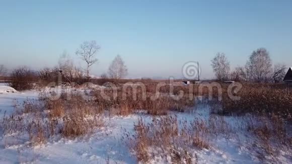 4k航空摄影冬季景观以观冻河灌木丛温暖的夕阳视频的预览图