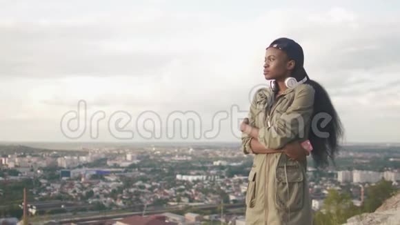 侧面肖像吸引人的年轻非洲女孩放松和享受全景城市视图4k视频的预览图