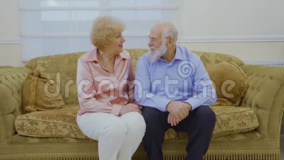 老人和妻子坐在家里客厅的沙发上聊天视频的预览图