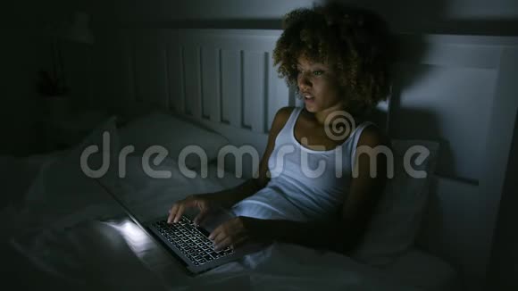 年轻女人晚上用笔记本电脑视频的预览图