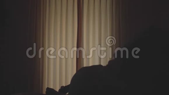 穿着浴袍的女人站在床上打开窗帘走向海景露台年轻女子看着视频的预览图