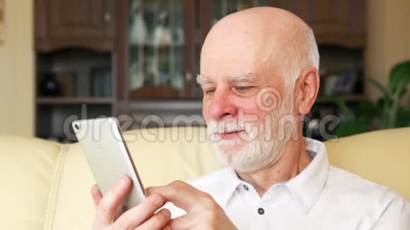 老人在家使用手机浏览阅读新闻退休后积极的现代生活视频的预览图