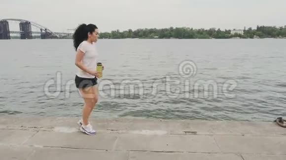 女士做热身运动跑到河边视频的预览图