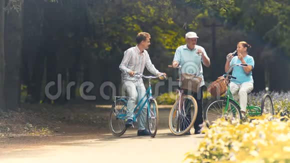 老两口在公园骑自行车时休息和喝水视频的预览图