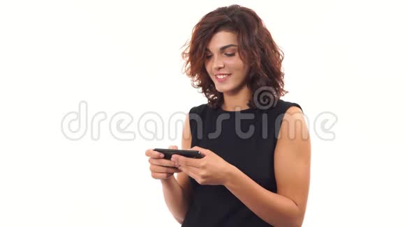 年轻的商务女性穿着黑色连衣裙使用手机打字信息触摸屏幕有魅力的女人视频的预览图