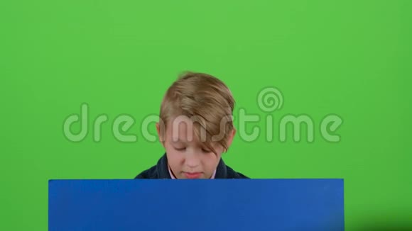 十几岁的孩子从黑板后面偷看在绿色的屏幕上表示不喜欢视频的预览图