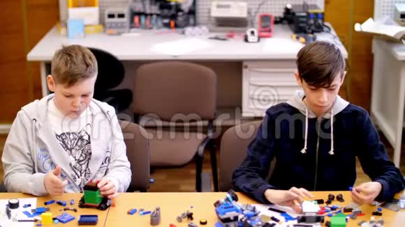 十二岁的男孩从立方体盘子电路电线中扮演设计师小发明家创造机器人机器来自视频的预览图