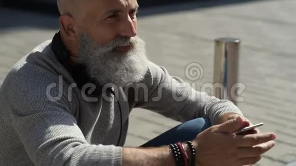 一个思想积极有胡子的人在街上打电话视频的预览图