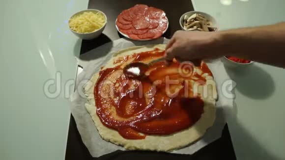 男厨抹红酱辣披萨生面团预制视频的预览图