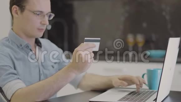 男子在笔记本电脑上插入信用卡号码视频的预览图
