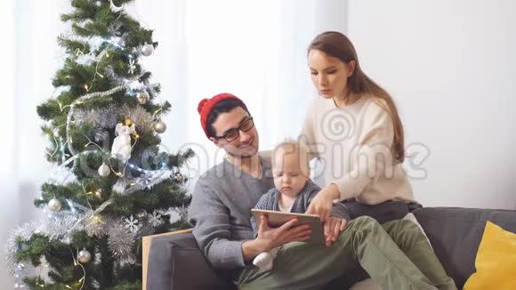 年轻的家庭在网上商店选择圣诞礼物视频的预览图