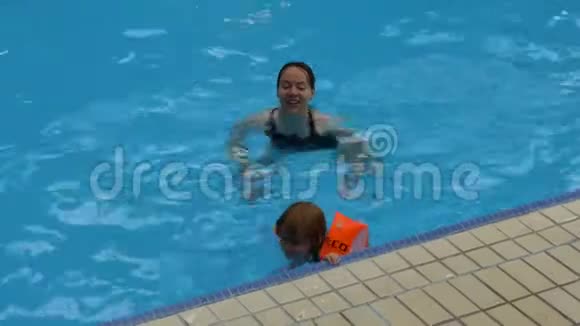 母亲和女儿在游泳池里视频的预览图