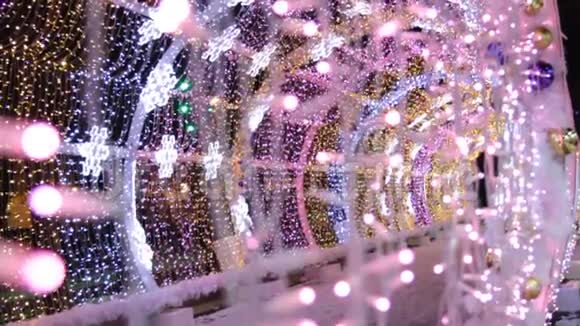 关闭彩色LED灯泡的花环在光隧道圣诞街道装饰城市新年准备视频的预览图