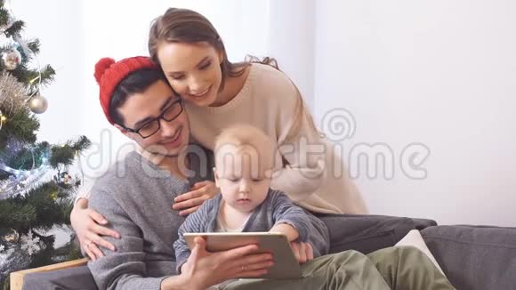 年轻的家庭在网上商店选择圣诞礼物视频的预览图
