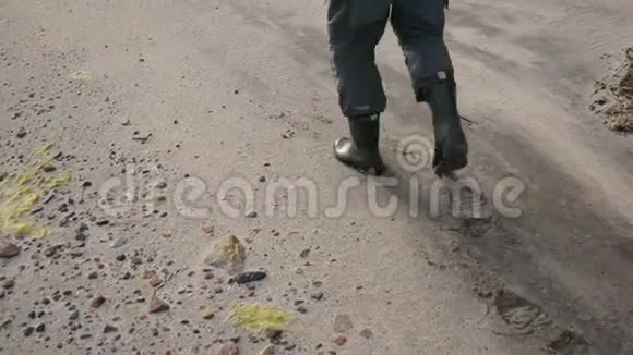 男子腿在靴子行走在沙滩上留下脚印4K视频的预览图