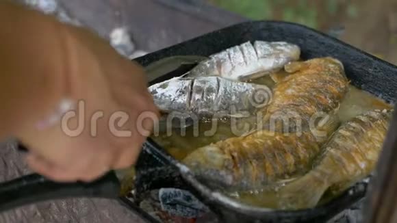 在煎锅和烤架里用油煮鱼在露天煎鱼专业餐饮美味脆脆的食物视频的预览图