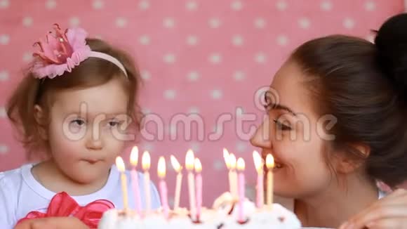 快乐的妈妈和孩子许愿在聚会上吹灭生日蛋糕上的蜡烛母亲祝贺拥抱和视频的预览图