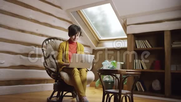 坐在椅子上用笔记本发短信的女人视频的预览图