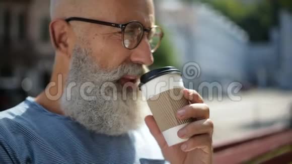 戴眼镜的高级绅士在户外喝咖啡视频的预览图