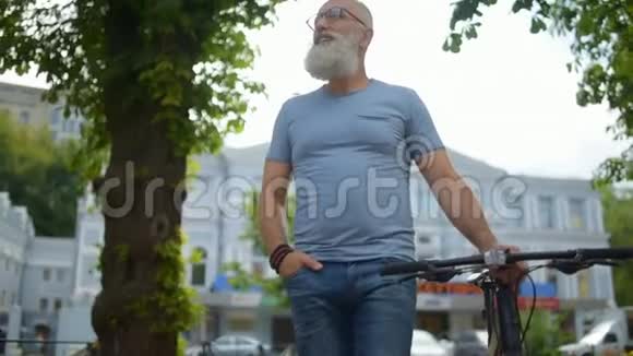 走路的时候一个头发花白的人骑着自行车在城市里检查视频的预览图