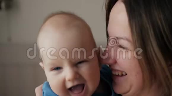 年轻的母亲抱着她的新生儿熟睡的孩子家里的家人卧室里的妈妈和小男孩亲吻她视频的预览图